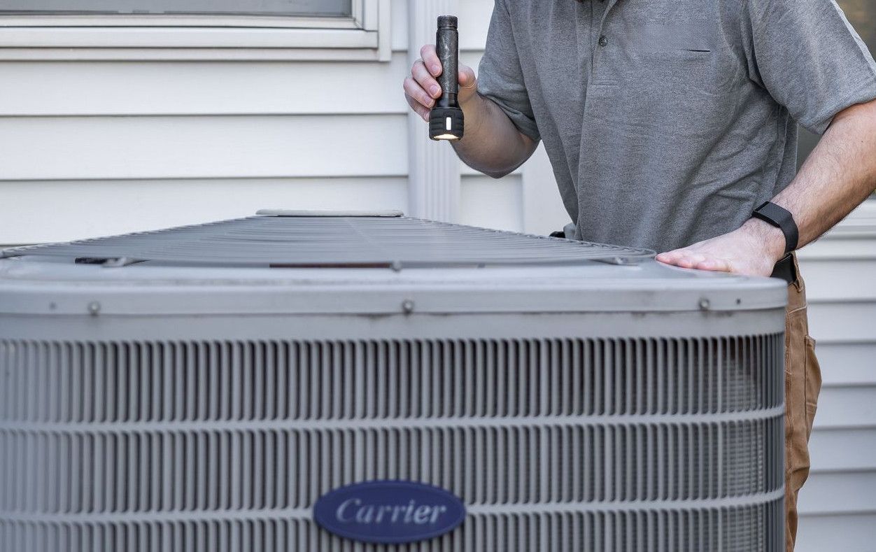 A technician inspects an outdoor HVAC unit for maintenance.